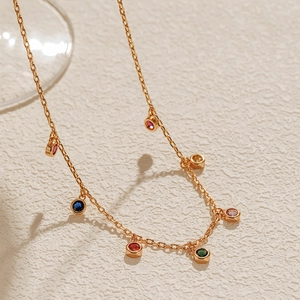 Detail of colorful round zircon pendants on a 18K gold plated copper chain necklace