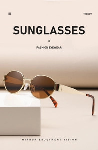 Detail of vintage oval sunglasses with gold metal frame and brown gradient lenses