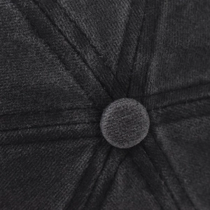 Gros plan d'une casquette en laine gris foncé montrant le bouton supérieur et les coutures