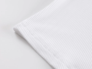 Macro shot of white ribbed fabric hem with double-needle stitching on athletic tank top