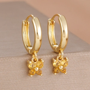 Détail de boucles d'oreilles papillon dorées à l'or 18 carats avec zircons brillants