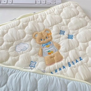 Detailed view of cloud quilted texture and cute bear embroidery on laptop sleeve