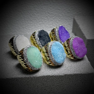 Set of 6 hammered gold adjustable rings with colorful crystal druzy stones on grey rock