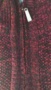 Close-up of the front zipper and collar on a thick red and black knit sweater jacket