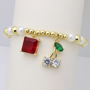 Dettaglio del bracciale di perline con ciondolo in gemma rossa e ciliegia di cristallo