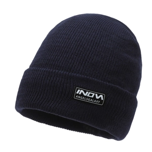 Berretto in maglia a costine blu scuro invernale con risvolto e patch logo su sfondo bianco