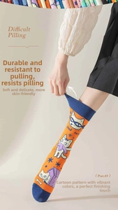 Close-up of elastic asymmetrical cotton socks with colorful cat patterns and high stretch