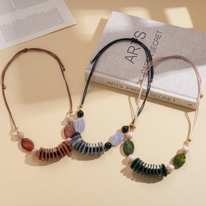 Three oval acrylic pendant necklaces on leather cords with vintage bohemian aesthetic