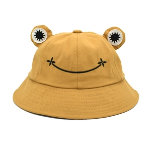 Detail of yellow cotton frog bucket hat with 3D eyes and embroidered smiley face