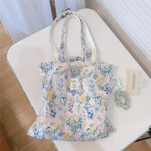 Detailed top view of large white floral canvas tote bag with rabbit patterns and straps