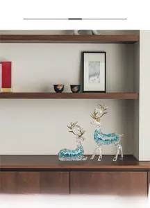 Detailed view of crystal resin elk figurines with blue fragments and gold horns on a shelf