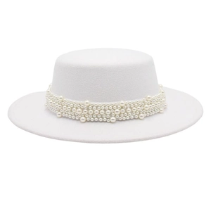 Detailed close-up of layered white pearls on a minimalist white wool felt flat top hat