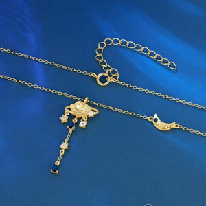 Detail of 925 silver celestial necklace with gold finish moon and blue drop charms