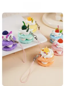 Makroaufnahme bunter Miniatur-Macaron-Anhänger mit Fruchtdetails und rosa Schlüsselbändern