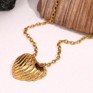 Gros plan d'un pendentif cœur plaqué or 18K texturé sur une chaîne en O dorée