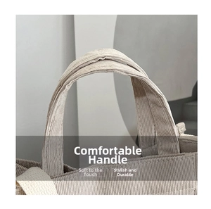 Detail of the reinforced stitching and durable handle on the corduroy handbag in beige grey