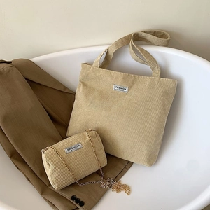 Detail of beige corduroy tote and small crossbody bag set with golden chain strap