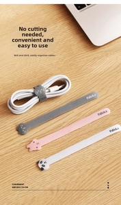 Detail of cute animal cable ties in grey, pink, and white on a wooden desk setup