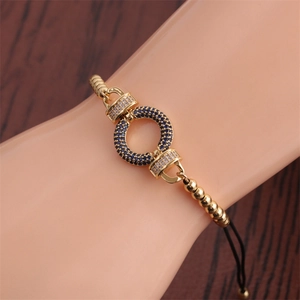 Adjustable gold bracelet featuring a circular motif set with blue and white cubic zirconia