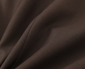 Macro view of dark coffee brown twill fabric texture and refined material drapery