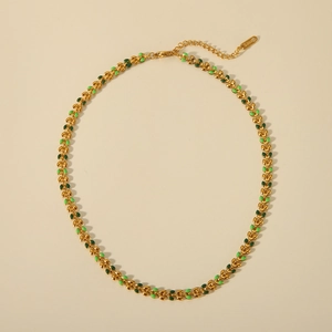 Close-up of golden stainless steel necklace with green enamel olive leaf links
