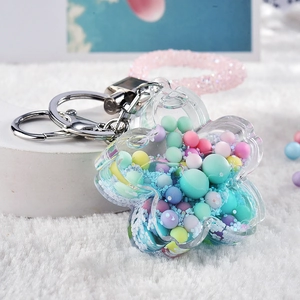 Close-up of acrylic flower keychain with colorful macaron beads and glitter filling