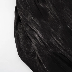 Gros plan sur un tissu noir au lustre métallique et texture plissée fine