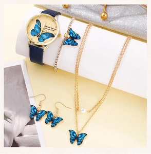 Close-up of five-piece jewelry set with blue butterfly watch and pearl necklace