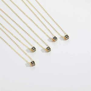 Minimalist square alphabet pendant necklace with gold letters on black cubes and gold chain