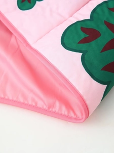 Detail of pink floral quilted jacket featuring precise edge piping and satin lining