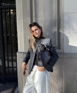 Détail rapproché du blazer gris à carreaux et sac à main en cuir marron
