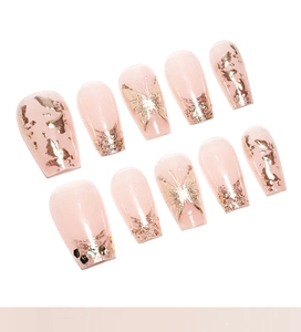 Nahaufnahme französischer Kunstnägel in Nudepink mit Goldglitzer und Schmetterling