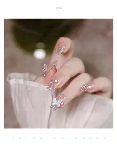 Close-up of butterfly nail charms with pearls and crystals in baroque style art