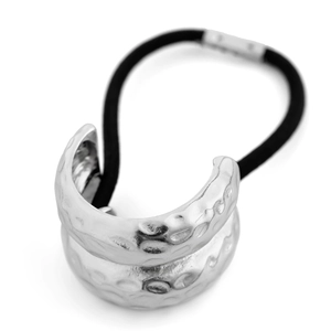 Close-up of a black elastic hair tie featuring an irregular hammered silver metal charm