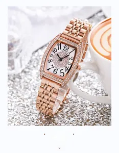 Gros plan d'une montre tonneau en or rose avec cadran pavé de cristaux étincelants