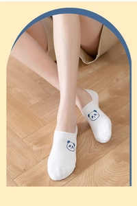 Close-up of white cotton low-cut socks with blue panda logo on a wooden floor