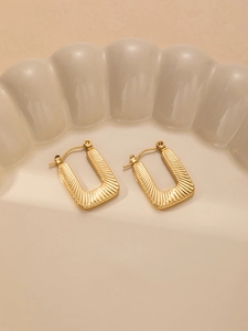 Detail showing golden sunburst texture on rectangular titanium steel earrings with clasp