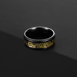 Gros plan d'une bague en titane noir avec des engrenages steampunk dorés sur pierre