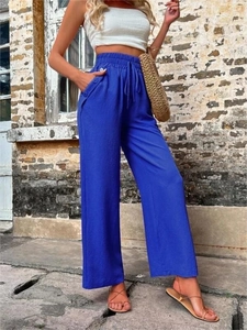 Détail du pantalon bleu à taille haute avec cordon de serrage et boutons latéraux