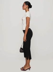 Detail view of black cropped flare pants with split hem and stylish bow at high waist