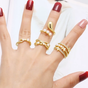 Set of five gold pearl and butterfly rings featuring elegant crossover and zircon designs