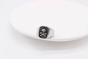 Detailed close-up of retro skull and crossbones design on vintage steel signet ring