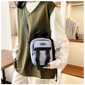 Dettaglio di una borsa a tracolla in nylon azzurro con etichetta fashion e fibbia a scatto