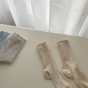 Detail of speckled cotton socks with ribbed texture in beige and light blue colors