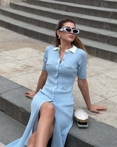 Detail of light blue knit dress with white contrast collar and pearl button closure