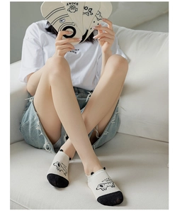 Detail showing white cotton ankle socks with cute dog patterns and non-slip design