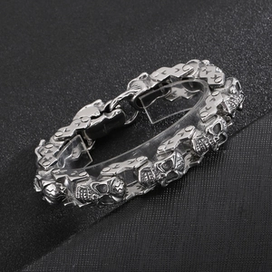 Détail du bracelet gourmette tête de mort argenté avec gravures gothiques et textures