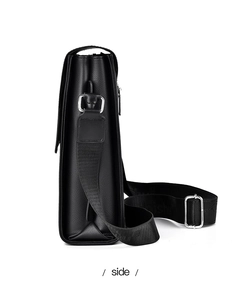 Side view of black pebble leather crossbody bag with silver buckle and fabric strap