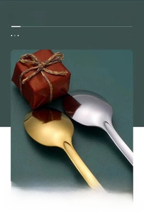 Detail showing polished gold and silver stainless steel spoons on a matte green background