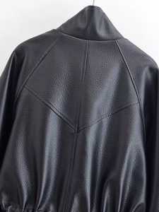 Macro shot of back yoke with V-shaped stitching on black faux leather jacket